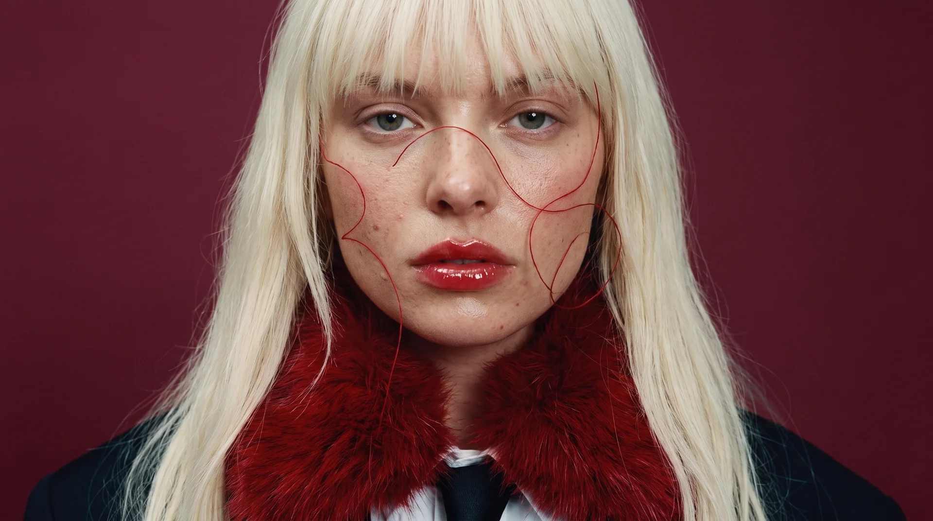 Portrait serré, lèvres rouges, fils rouges sur le visage